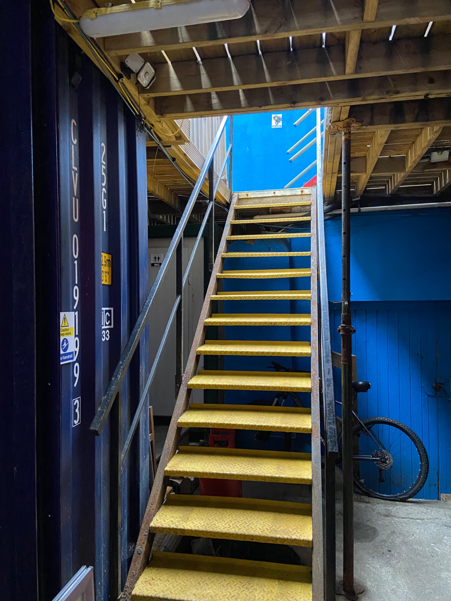 Yellow stairs leading up to The Velvet Blade Barbershop